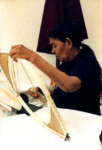 Mani-Aten Penashue laces a snowshoe at Kamashkushkatinau-nipi. Photo courtesy Camille Fouillard.